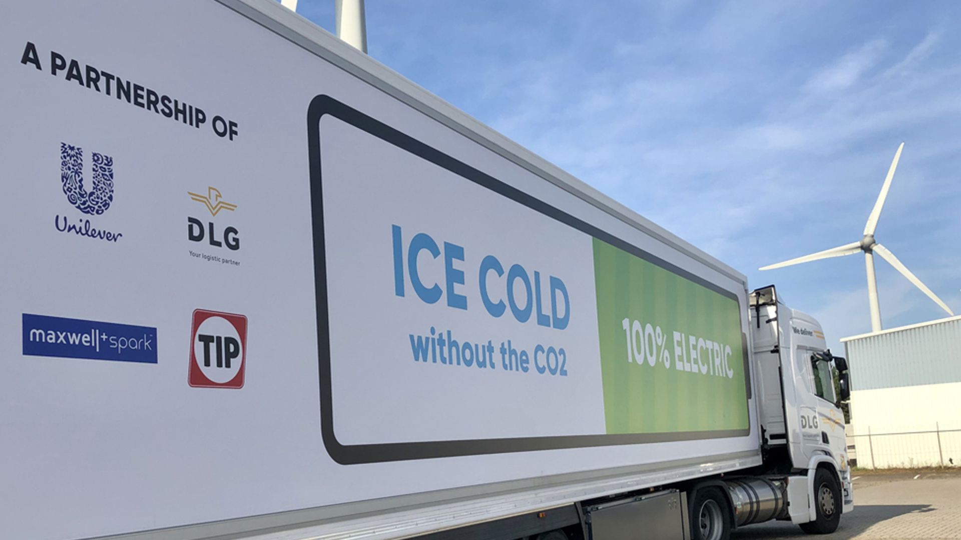 Truck trailer showing partner logos as well as the words “Ice cold without the CO2” and “100% Electric” in large letters.