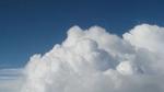 A photo of a blue sky with large white clouds in the foreground