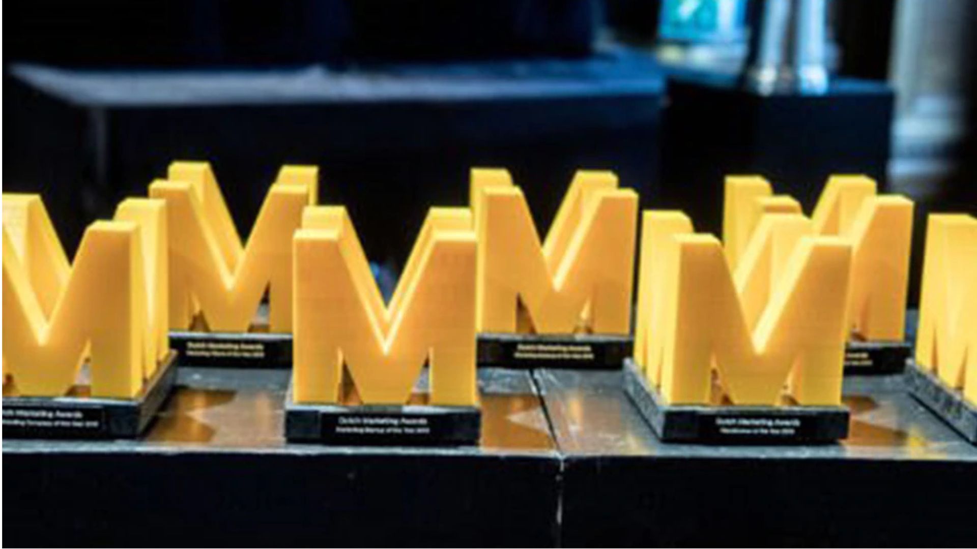 Rows of yellow, M-shaped awards. Photo by Bart van der Putten