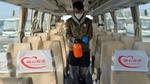 A man walks down the aisle of a bus with cleaning equipment