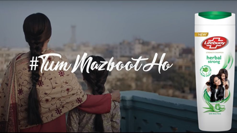 A daughter standing with her mother with Lifebuoy shampoo bottle placement on the right.