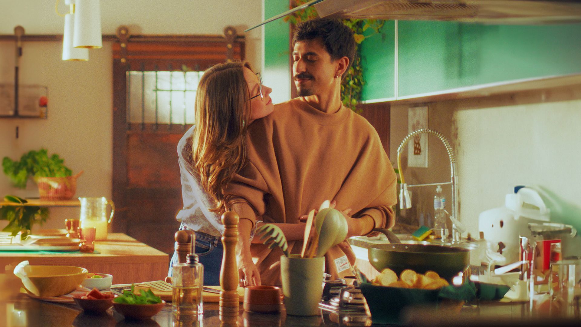 In a still from Knorr’s Green Flag social influencer marketing campaign, a woman hugs a man while he is cooking.