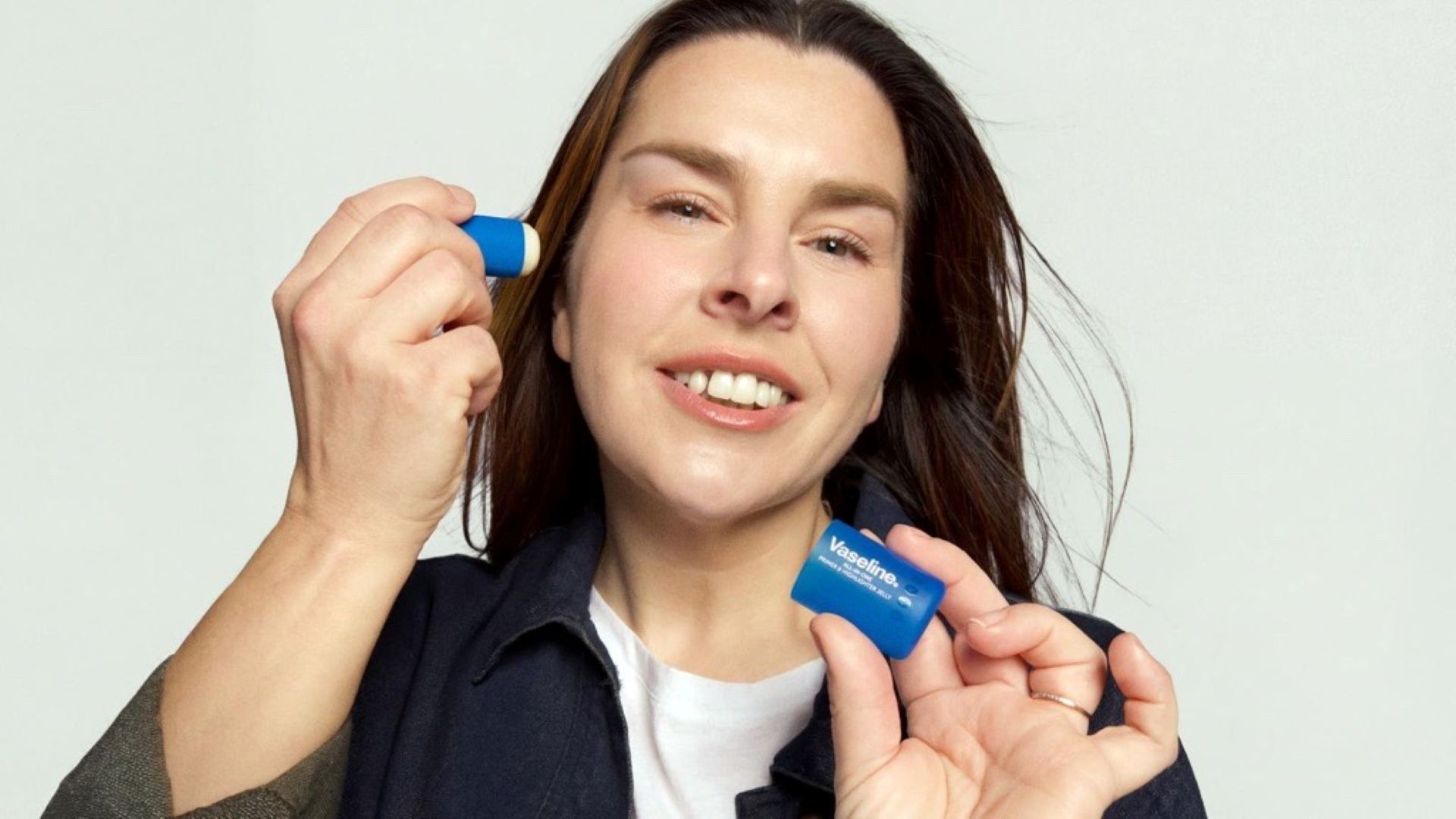 A photo of creator Lauren Luke holding the Vaseline Originals Primer & Highlighter product she helped design.